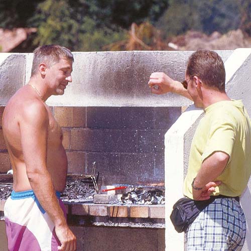 Deux campeurs faisant un barbecue au camping dans les Landes près de Vieux-Boucau