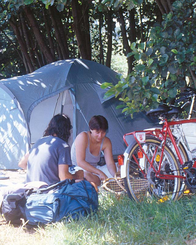 Pareja de campistas con carpa y bicicletas en el camping de Messanges en los años 90