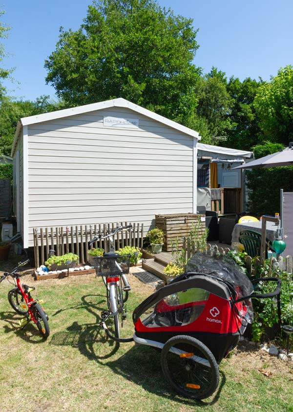 Bicicleta y su remolque aparcados delante de una casa móvil en las Landas