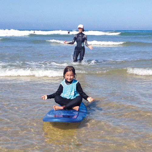 Enfant en bord de mer sur une planche de surf près de Hossegor